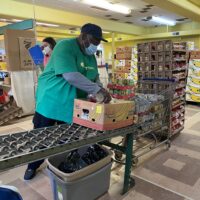 volunteer packing donated food box